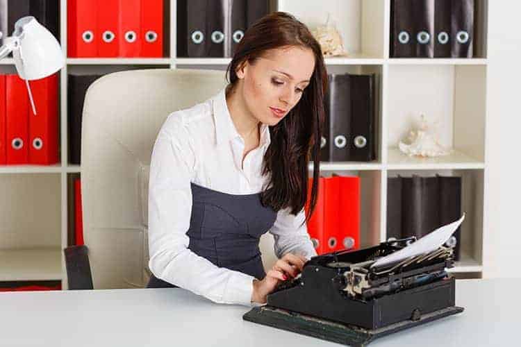 Woman typing letter on typewriter