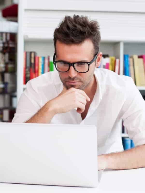 Man Working At Laptop In Library